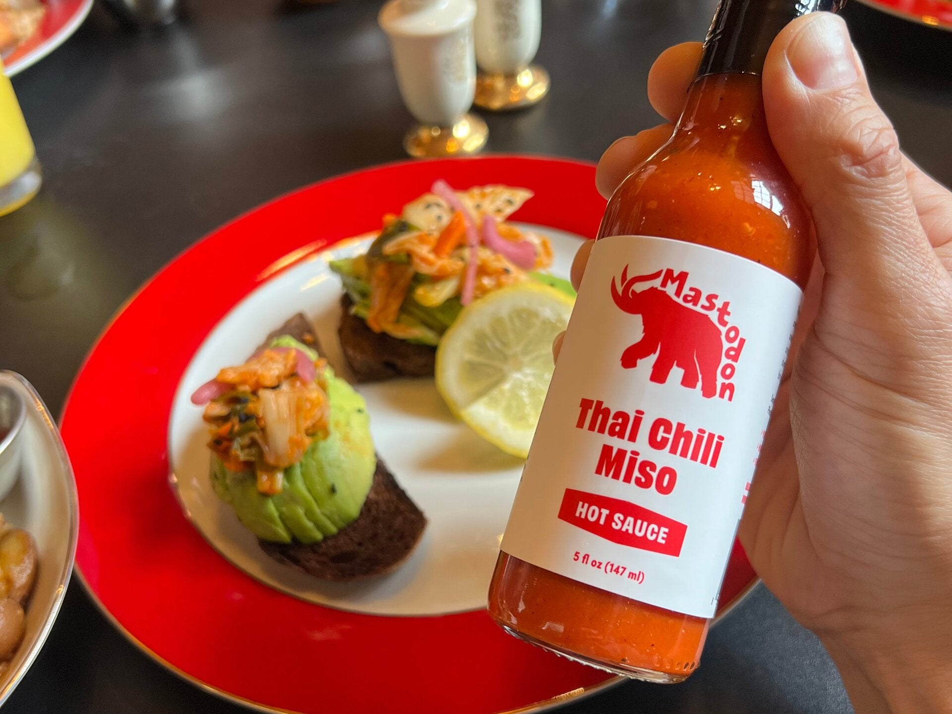 Mastodon Hot Sauce homepage hero — bottles in kitchen setting
